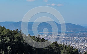 Cityscape of Athens in sunny day with sea shore and mountains seen from above, Greece