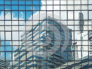 Cityscape background of blue sky with white clouds and skyscraper reflection on glass wall and windows