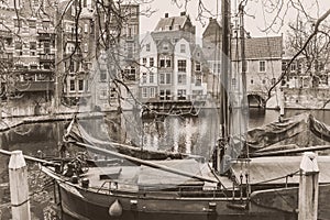 Cityscape, in black-and-white color - view of the canal and moored ship in the old district Delfshaven of Rotterdam