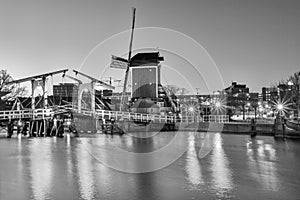 Cityscape, black-and-white - evening view of the city canal with drawbridge and windmill, the city of Leiden