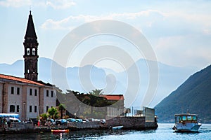 Cityscape and boat on background of mountains. View of Perast old town in Bay of Kotor, Montenegro.