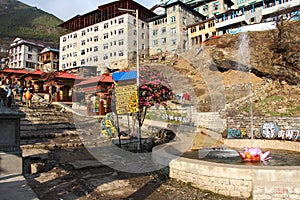 Cityscape of central part of Namche Bazaar town with fountain and prayer wheels