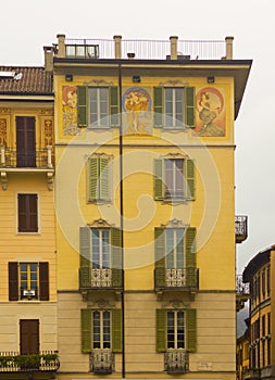 Cityscape of decorated faÃ§ade with wood green shutters Como Italy photo