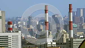 Cityscape with factory pipes in foreground