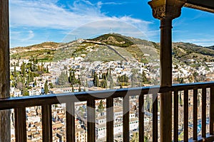 Cityscape of Granada with a hill in background against blue sky