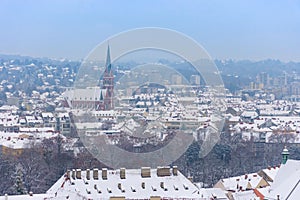 Cityscape of Graz with Church of the Sacred Heart of Jesus and historic buildings rooftops with snow, in Graz, Styria region,