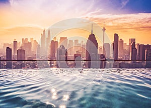 Cityscape of Kuala lumpur city skyline with swimming pool on the roof top of hotel at sunrise in Malaysia