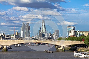 Cityscape of London in late afternoon light from Hungerford Bridge.