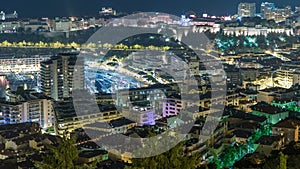 Cityscape of Monte Carlo, Monaco night timelapse with roofs of buildings and traffic on roads.