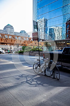 Cityscape and parked bicycles with morning summer shadows in Chicago Loop