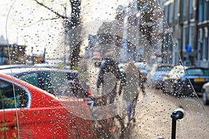 Cityscape on a rainy day - view through the windshield of the scooter on the street in the historic center of Amsterdam