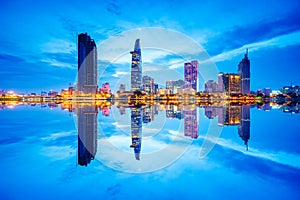 Cityscape in reflection of Ho Chi Minh city at beautiful twilight, viewed over Saigon river.