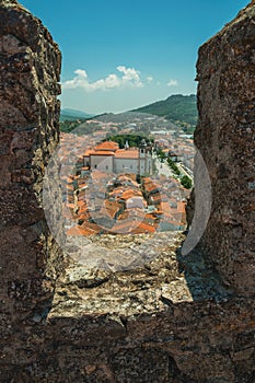 Cityscape with roofs and cathedral seen by crenel in the castle wall