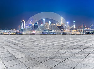 Cityscape and skyline of chongqing from empty brick floor at night