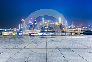 Cityscape and skyline of chongqing from empty brick floor at night