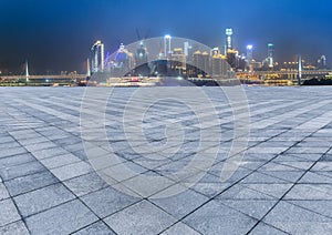 Cityscape and skyline of chongqing from empty brick floor at night