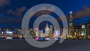 cityscape and skyline night scene of Hong Kong city at Victoria Harbour on view from empty concrete floor