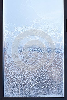 Cityscape through the snow-covered window