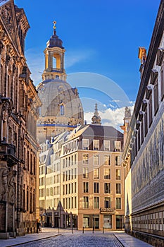 Cityscape - street view with Furstenzug Procession of Princes mural against the backdrop of the Dresden Frauenkirche