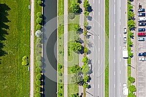 Cityscape in sunny day with water canal, street and parking lot with cars. top view aerial photo