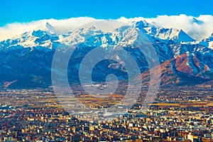 Cityscape of Turin with picturesque snowy Alps high rising on the background, Italy