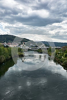 A cityscape with view of the Millenium Bridge on the Minho River seen from the Roman Bridge in the picturesque medieval city of