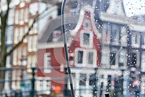 Cityscape - view on the old houses of Amsterdam in the rain through motorcycle windshield