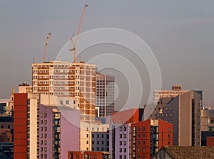 a cityscape view of tall modern residential developments in leeds city centre with a construction crane working on new