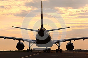 Civil airliner towing with truck at dawn