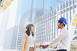 Civil Construction engineer teams shaking hands together wear work helmets worker on construction site. Foreman industry project