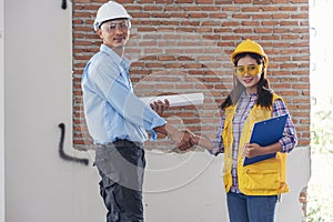 Civil Construction engineer teams shaking hands together wear work helmets worker on construction site. Foreman industry project