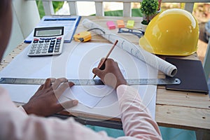 Civil construction engineer working with laptop at desk office with white yellow safety hard hat at office on construction site.