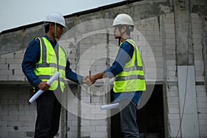 Civil Engineer with contractor partners are shaking their hands in construction building, agreement of partners in contract.