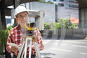 Civil engineer land survey with tacheometer or theodolite equipment. Worker Checking construction site on the road. Surveyor