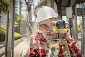 Civil engineer land survey with tacheometer or theodolite equipment. Worker Checking construction site on the road. Surveyor