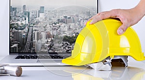 Civil Engineer is picking up safety helmet with Tokyo city background