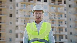 Civil engineer smiling at camera against skyscraper