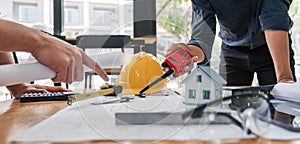 Civil engineer teams meeting working together wear worker helmets hardhat on construction site in modern city. Foreman