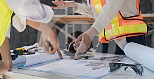 Civil engineer teams meeting working together wear worker helmets hardhat on construction site in modern city. Foreman