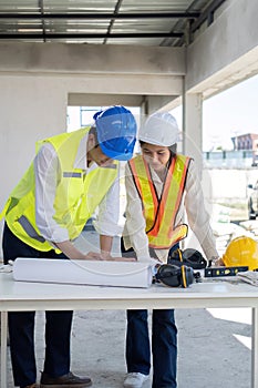 Civil engineer teams meeting working together wear worker helmets hardhat on construction site in modern city. Foreman