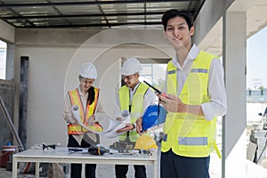 Civil engineer teams meeting working together wear worker helmets hardhat on construction site in modern city. Foreman