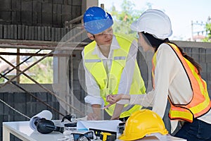 Civil engineer teams meeting working together wear worker helmets hardhat on construction site in modern city. Foreman