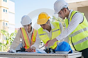 Civil engineer teams meeting working together wear worker helmets hardhat on construction site in modern city. Foreman