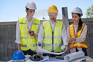 Civil engineer teams meeting working together wear worker helmets hardhat on construction site in modern city. Foreman