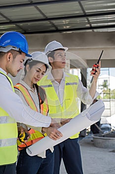 Civil engineer teams meeting working together wear worker helmets hardhat on construction site in modern city. Foreman