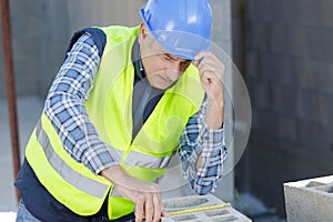 Civil engineer wearing protective white helmet checking measurements