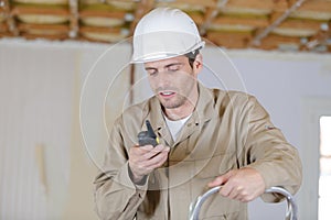 civil engineer wearing safety helmet using radio walkie talkie