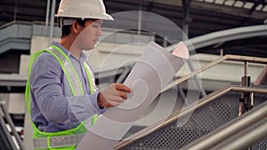 Civil engineer work inspecting architect drawing on construction site.