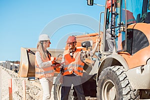 Civil engineer and worker discussion on road construction site