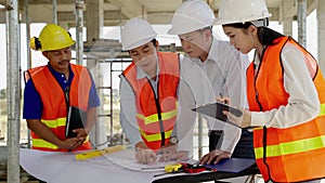 Civil engineering team Along with the architect and foreman watching the Blue Print and planning the construction of the building